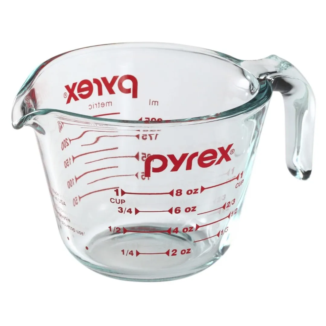 Pyrex-Messbecher aus Glas mit roter Skala und rotem Markenschriftzug, freigestellt auf Weiß