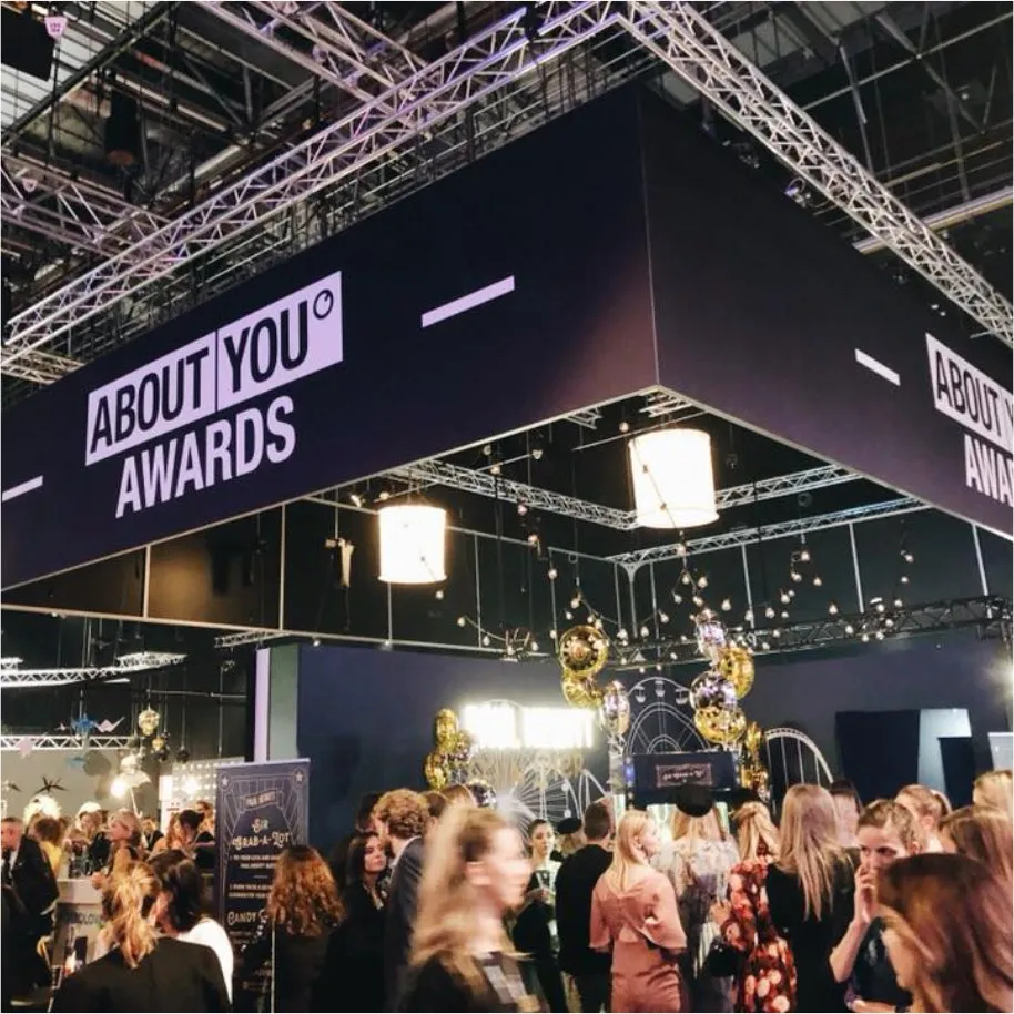 ABOUT YOU Awards: abgehängter Bühnenrahmen mit Markenschriftzug über einer Menge von Gästen