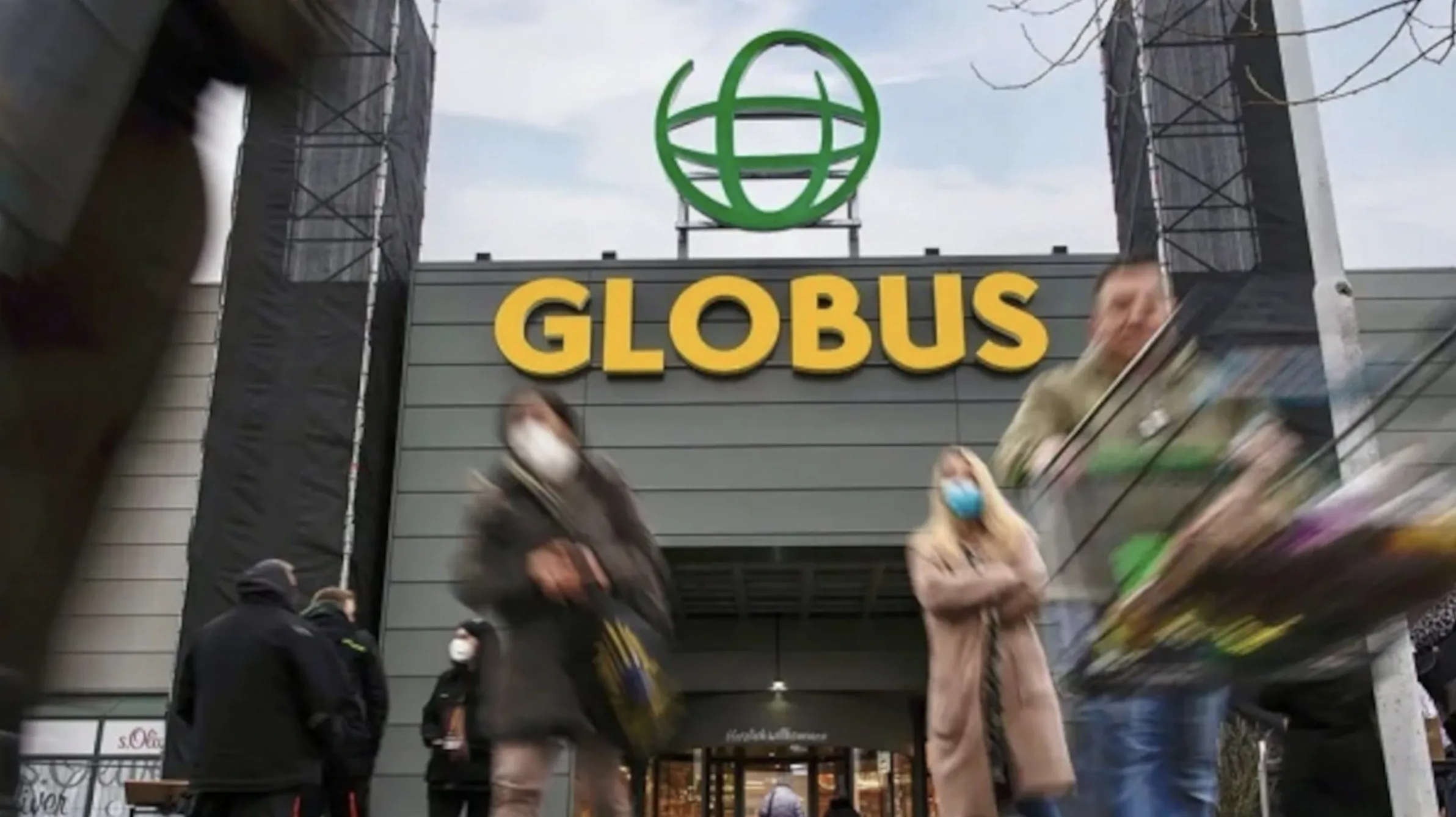 Eingang eines Globus-Markts mit Logo und Kundschaft