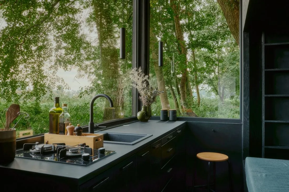 Küche einer StayRaus-Kabine mit Fensterband zum Wald